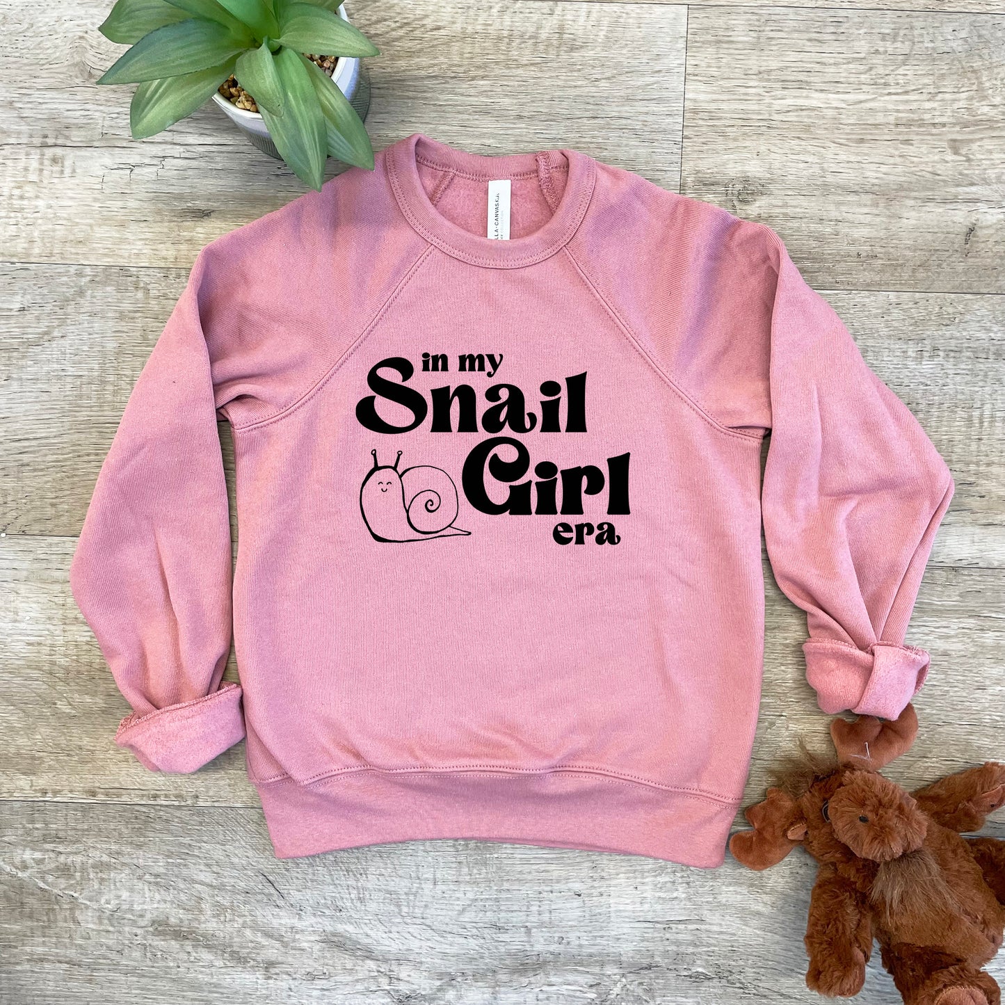 a pink sweatshirt that says in my snail girl