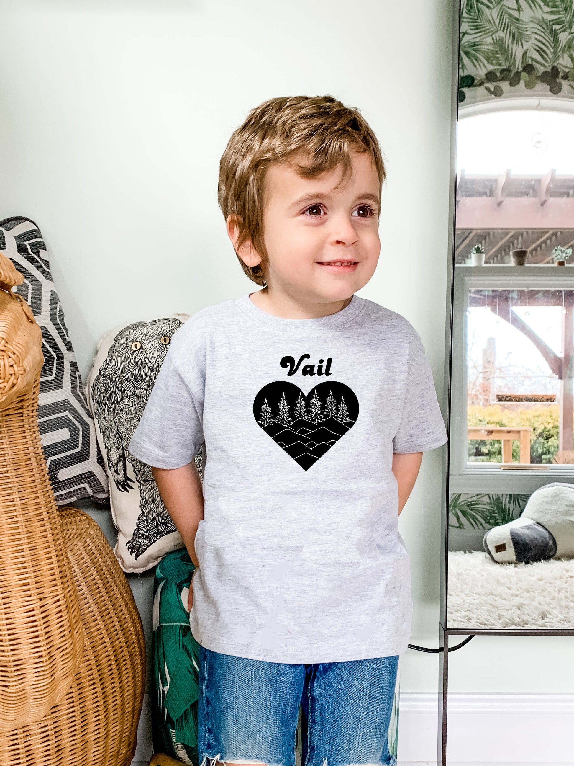 a young boy standing in front of a mirror