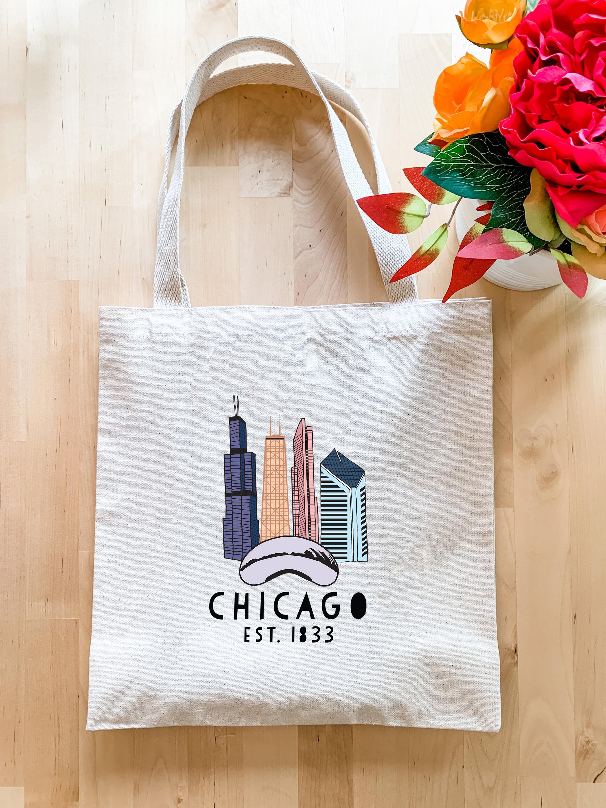 a chicago bag sitting on a table next to a vase of flowers
