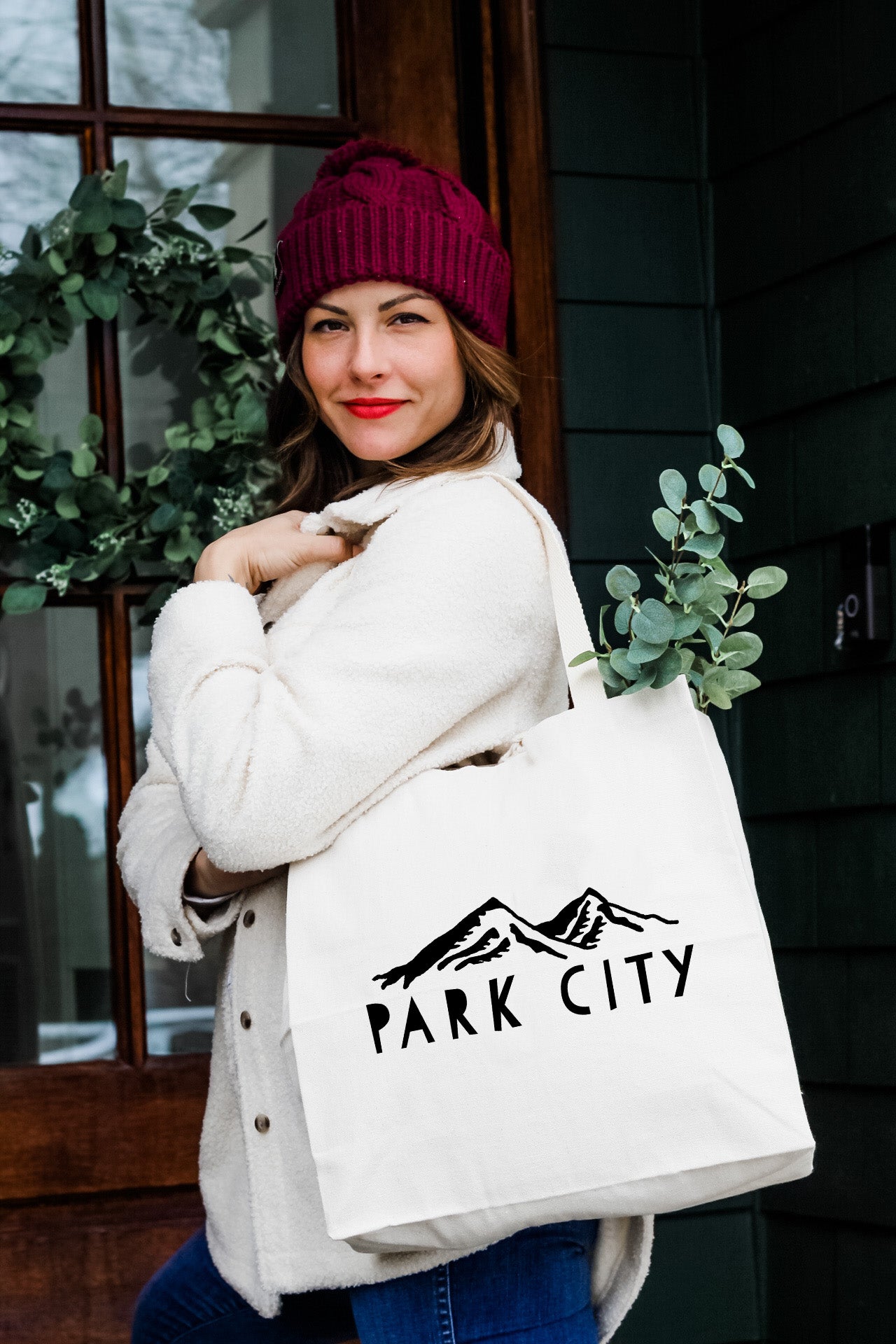 a woman carrying a white bag that says park city