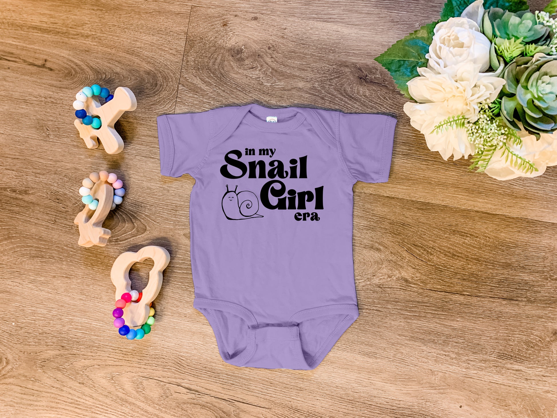 a baby bodysuit with the words snail girl on it