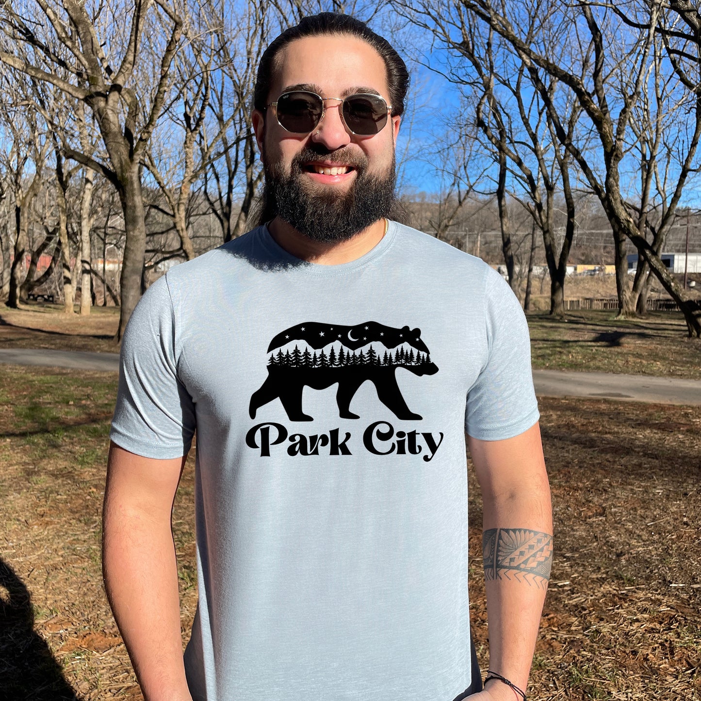 a man wearing a park city t - shirt and sunglasses