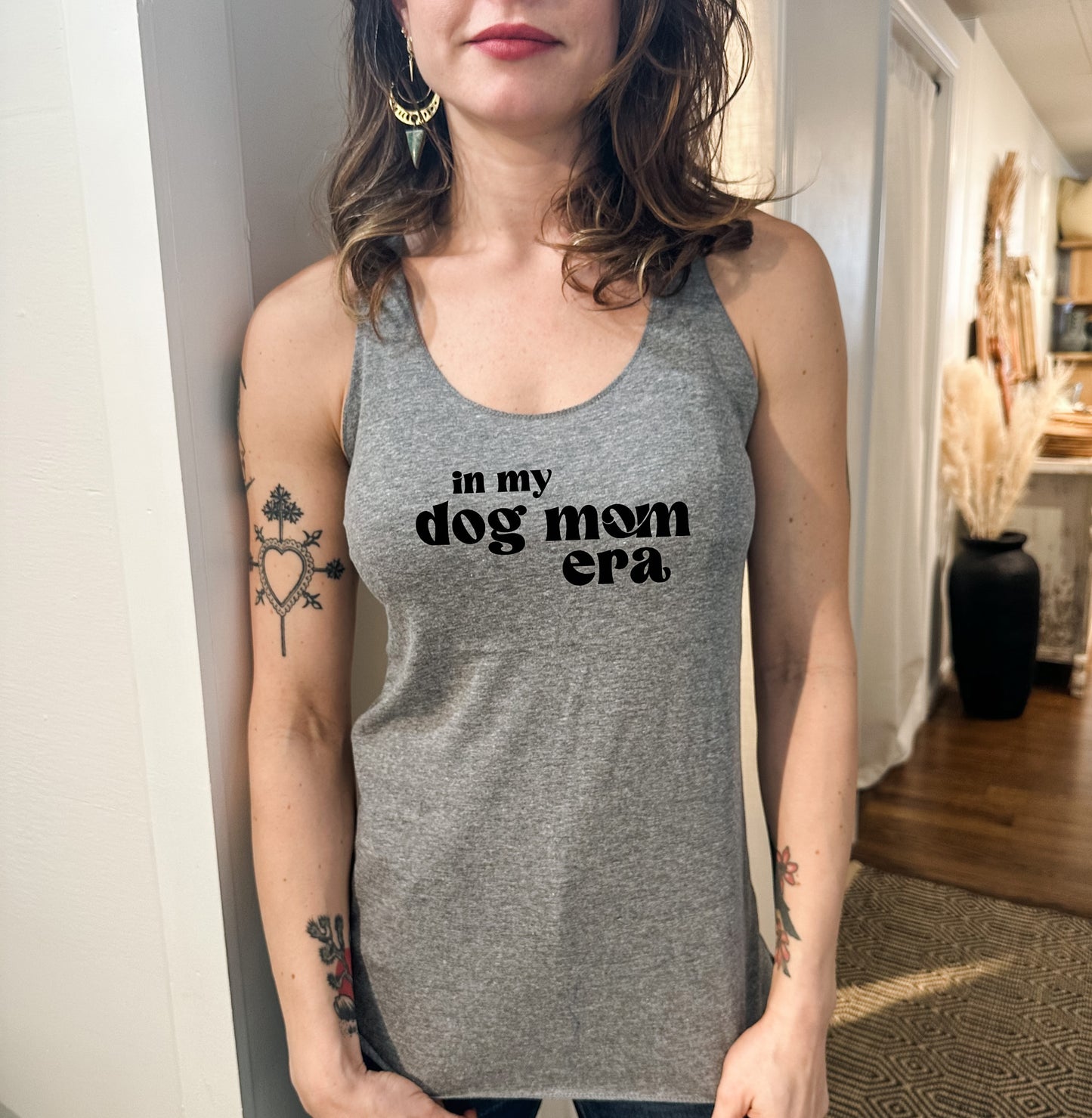 a woman wearing a tank top that says, in my mom's arms