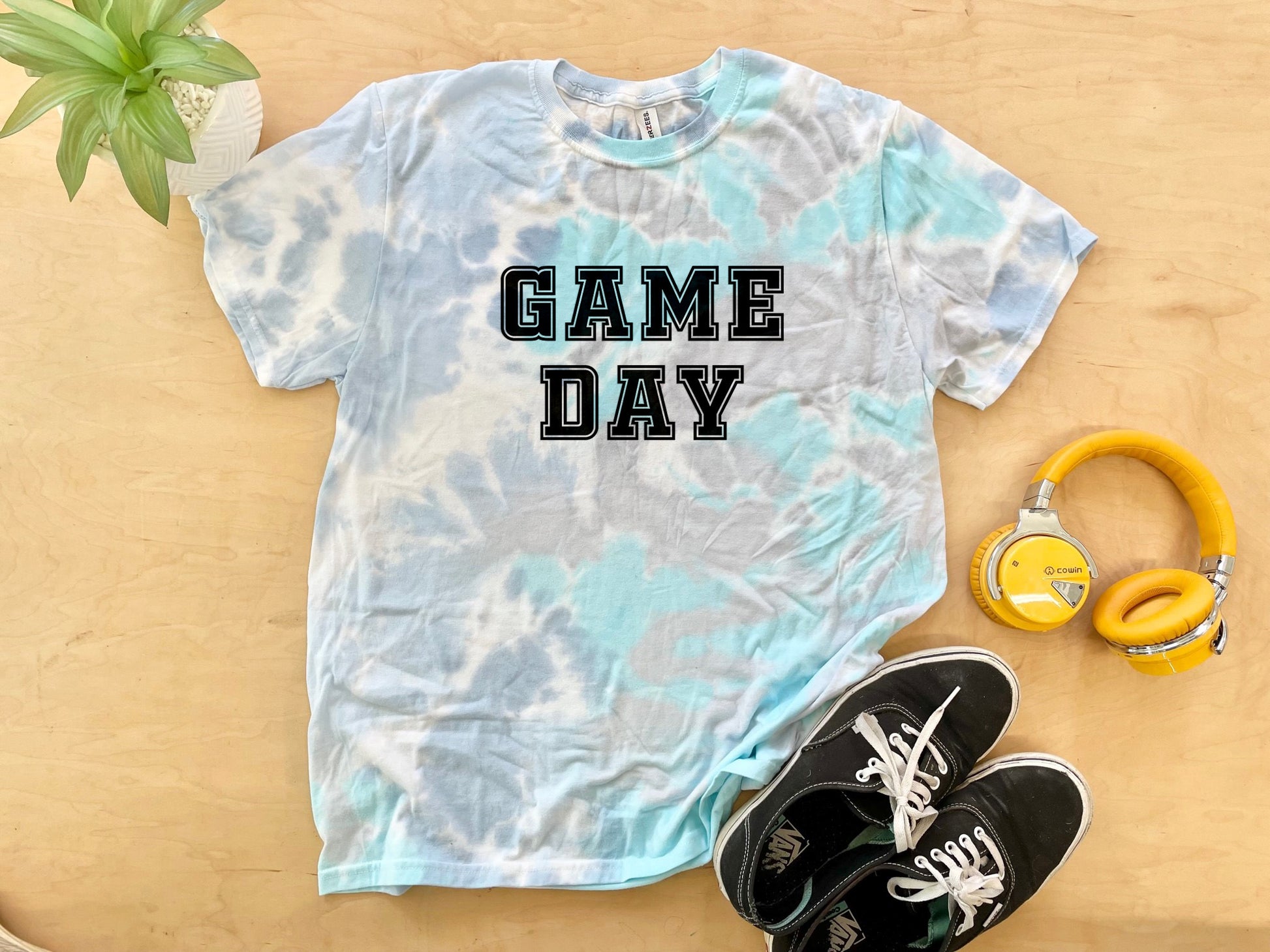 a t - shirt that says game day next to headphones and a pair of