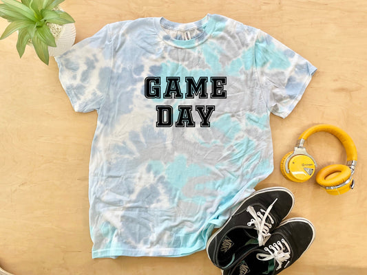 a t - shirt that says game day next to headphones and a pair of