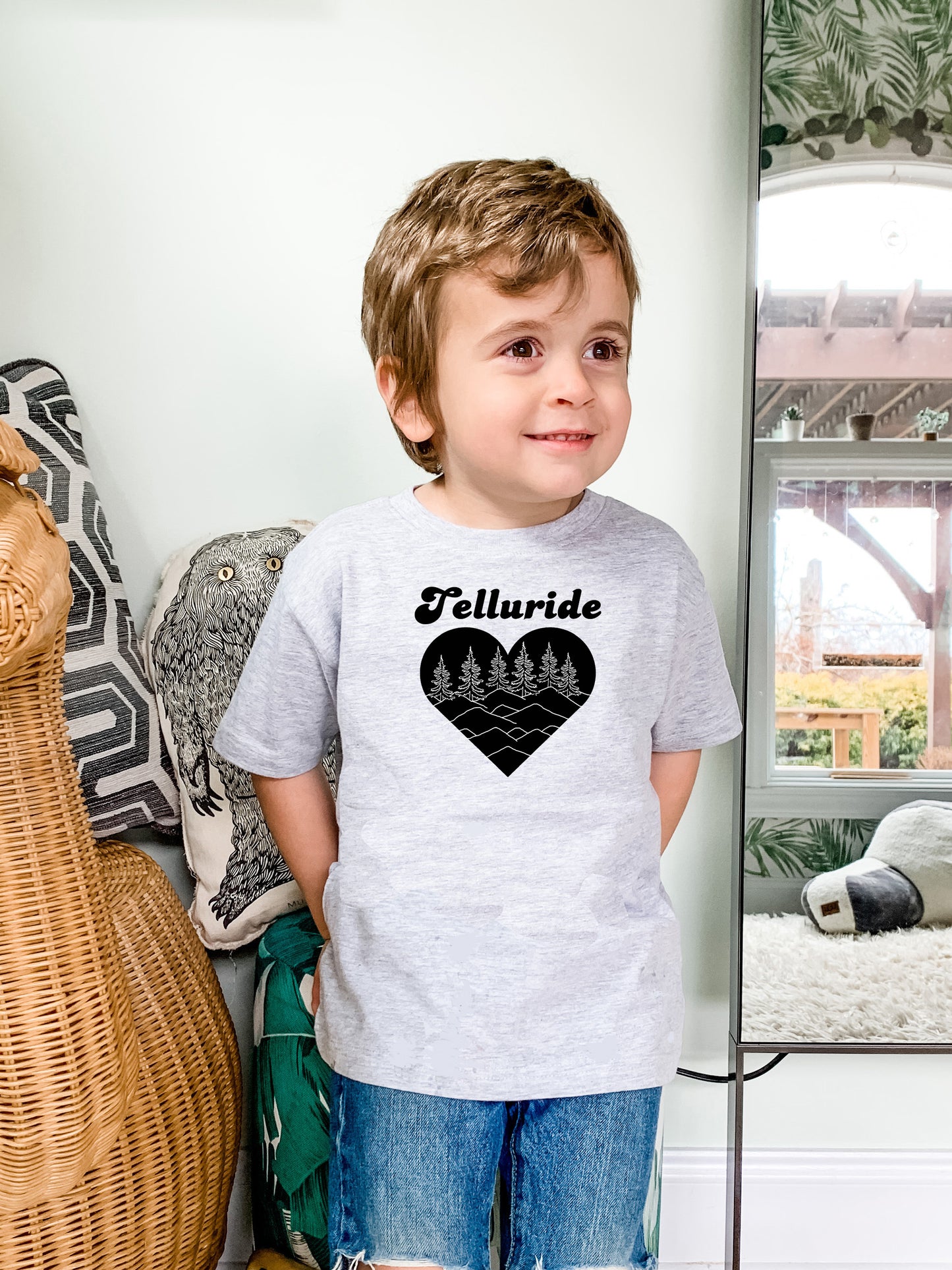 a young boy standing in front of a mirror