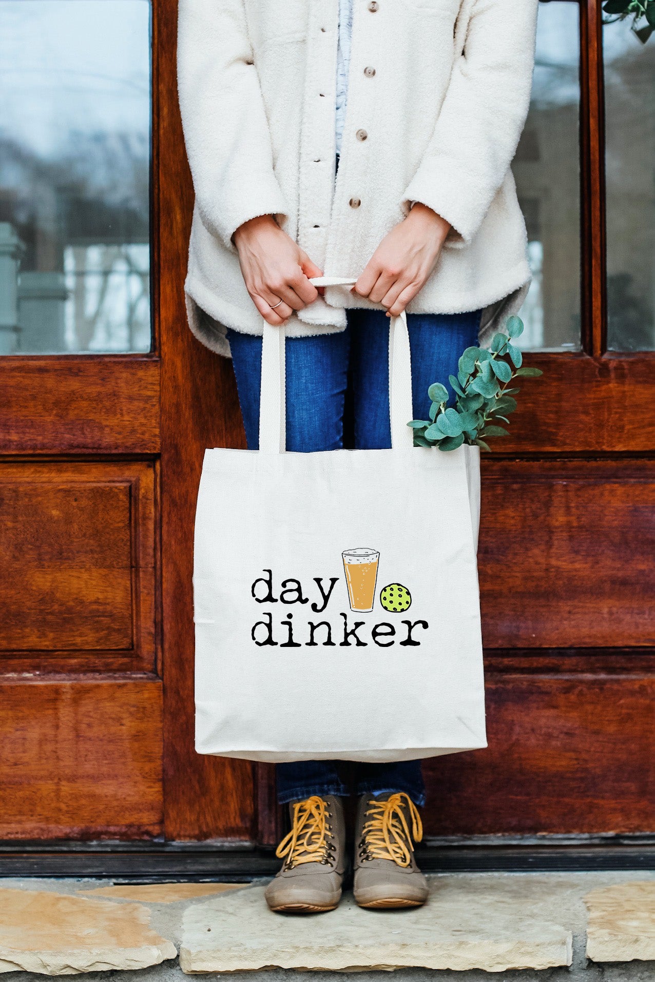 a woman holding a bag that says day drinker