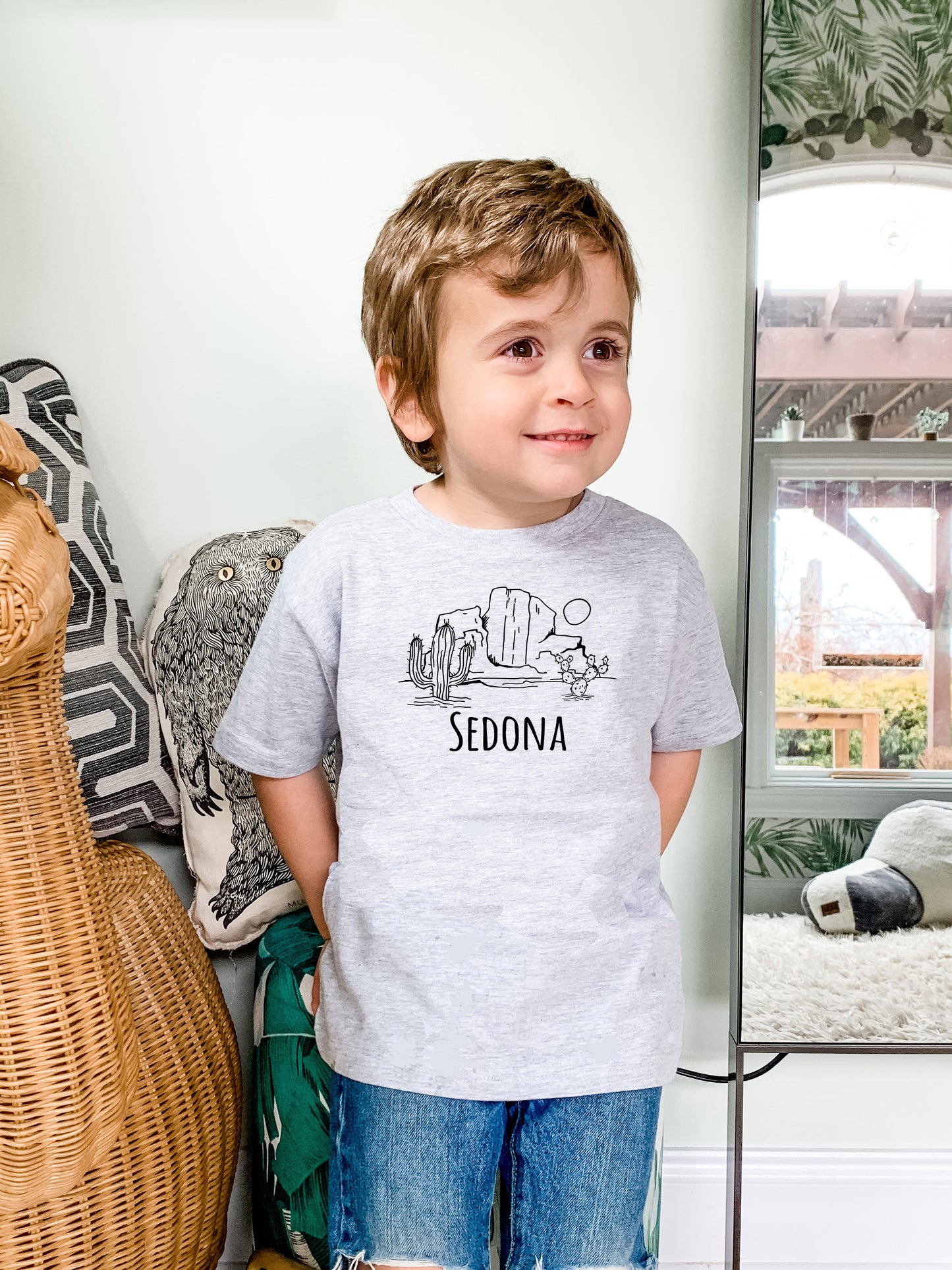 a young boy standing in front of a mirror