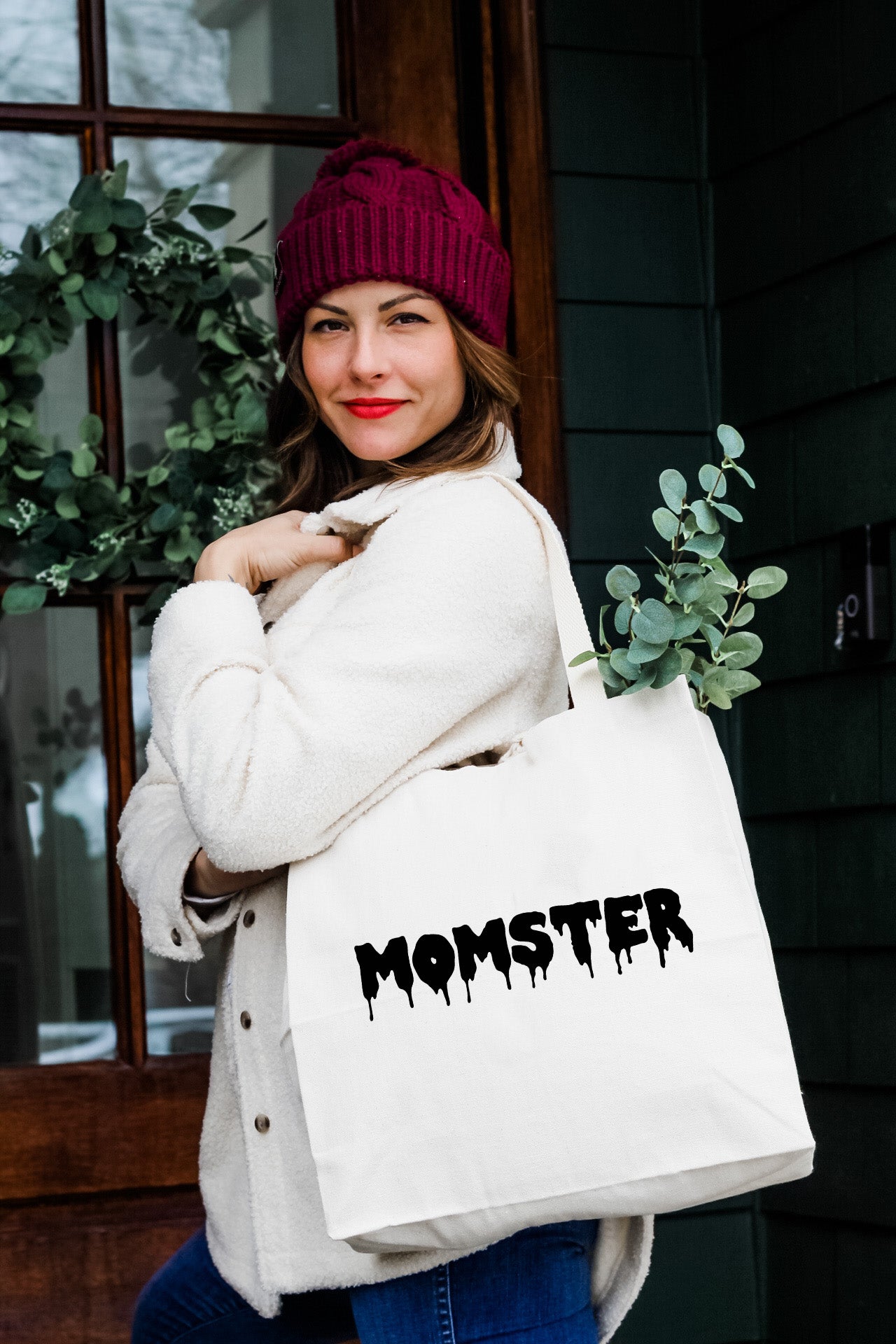 a woman carrying a white bag with the word monster on it