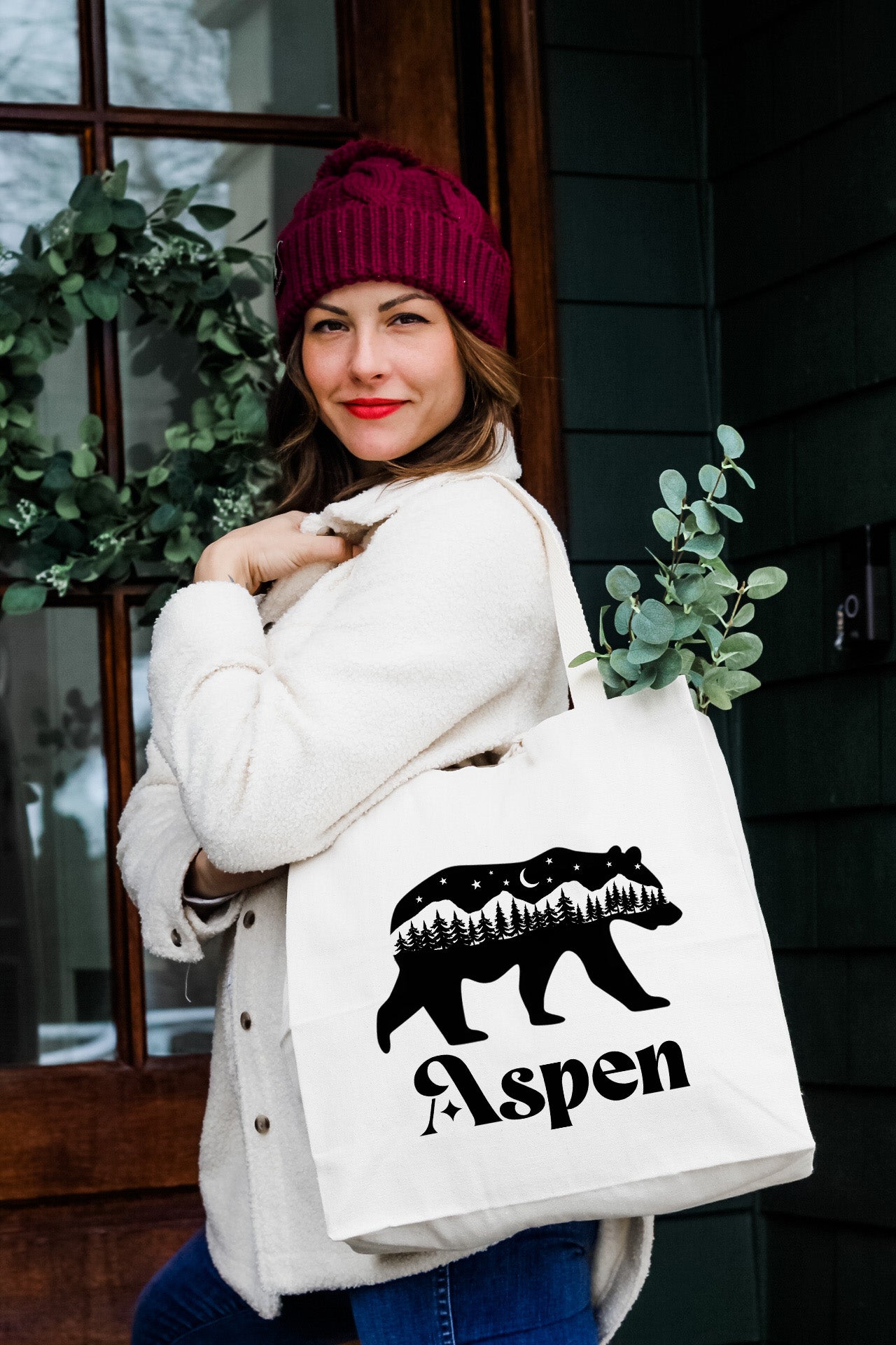a woman holding a white bag with a bear on it