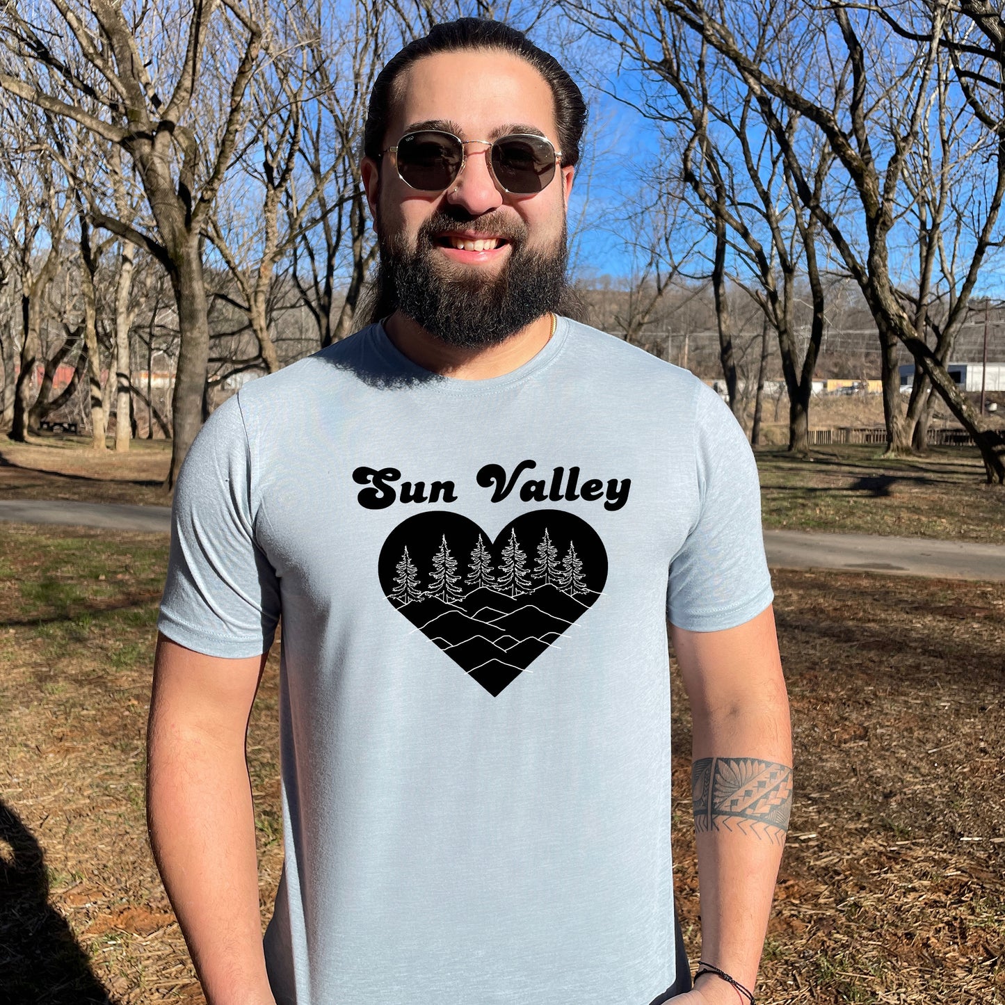a man with a beard wearing a sun valley t - shirt