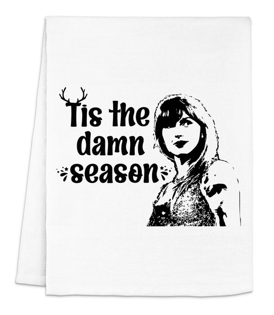 a white dish towel with the words tis the damn season printed on it