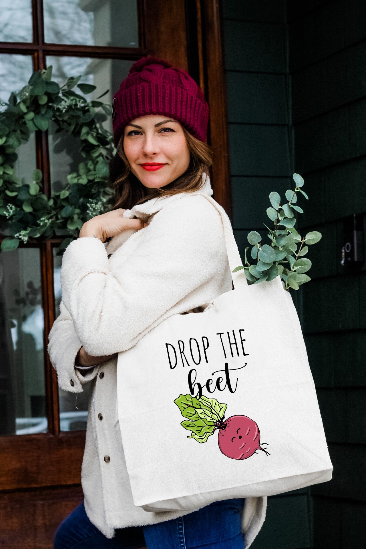 a woman carrying a bag that says drop the beet