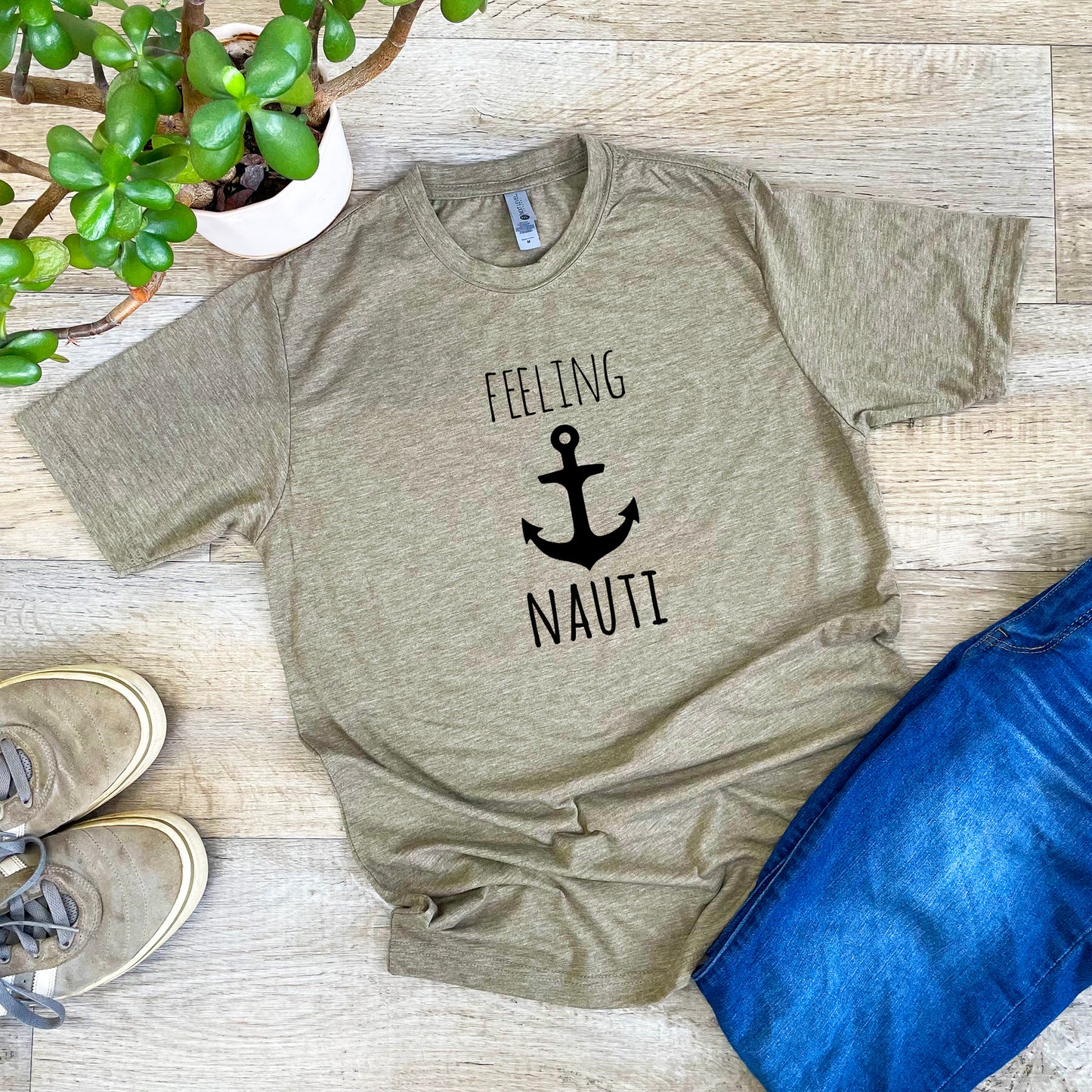 a t - shirt that says feeling nautit next to a potted plant
