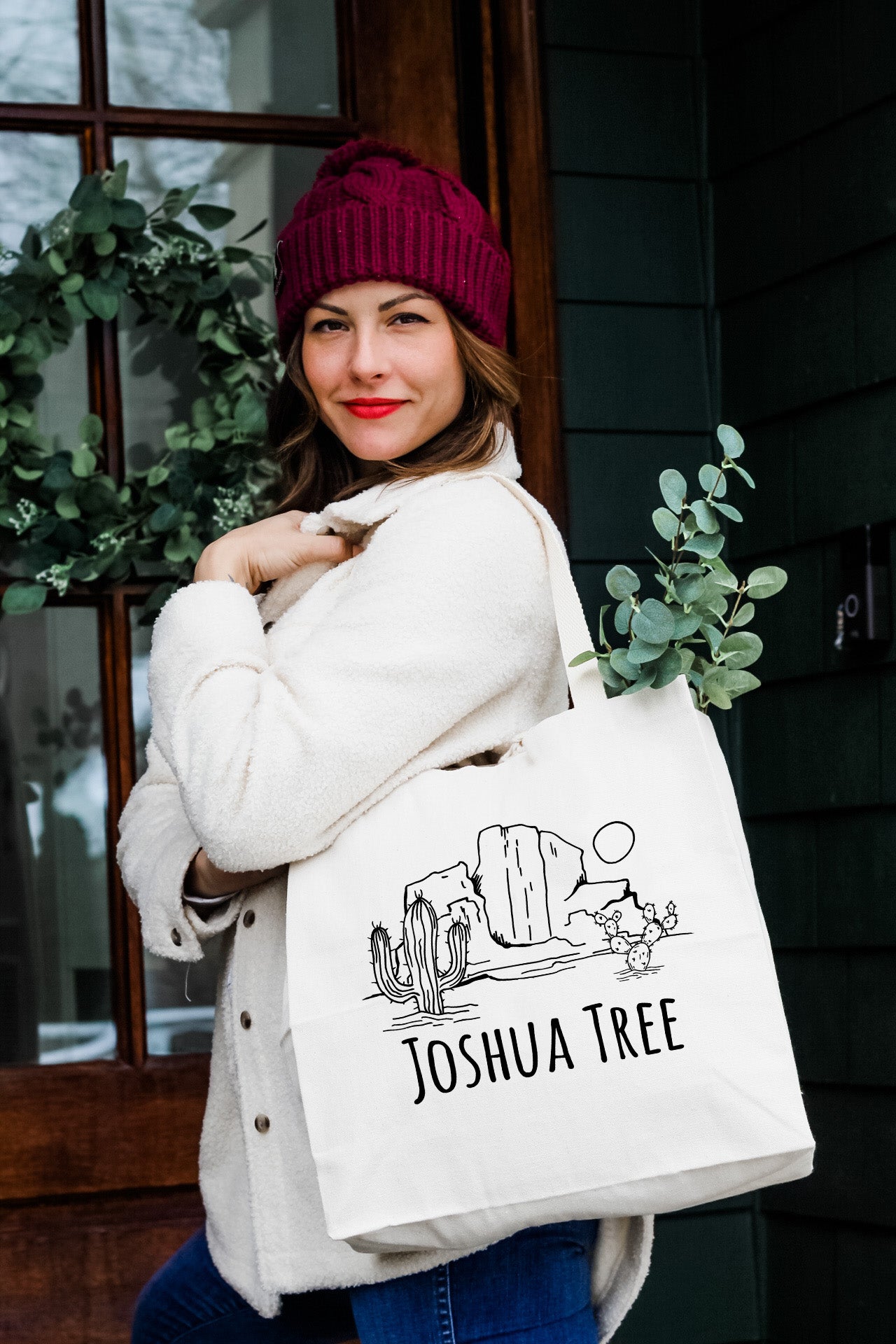 a woman carrying a tote bag that says joshua tree