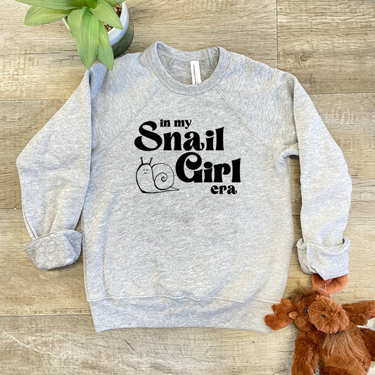 a sweatshirt that says in my snail girl on it next to a teddy bear