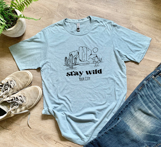 a t - shirt that says stay wild next to a pair of jeans
